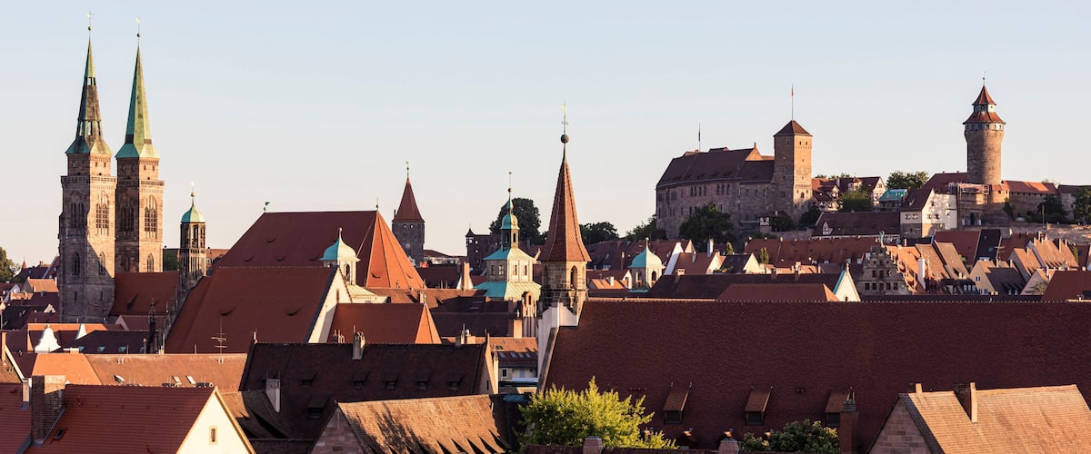 A historic town with prominent church spires, a castle, and a mix of traditional and modern architecture.