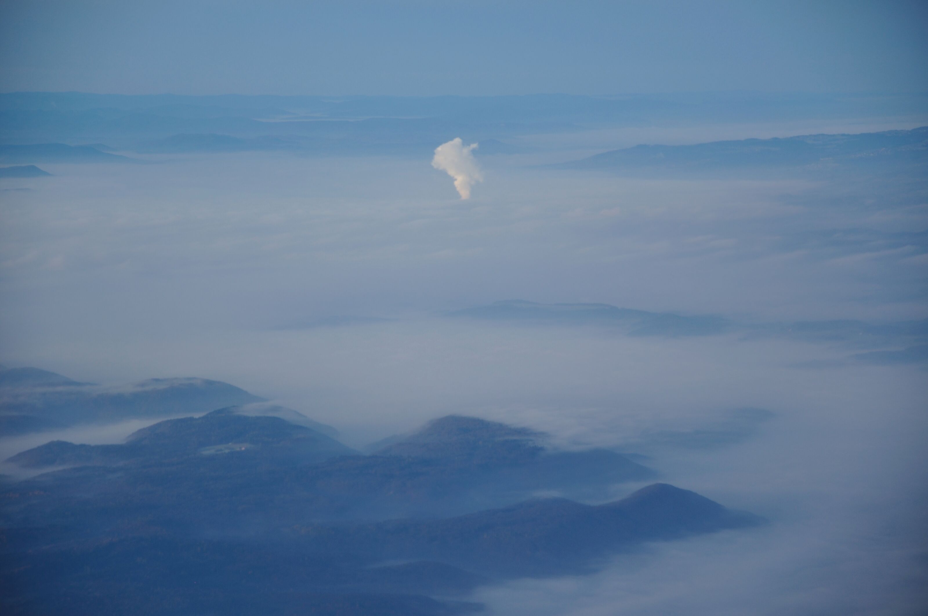 Germany, the steam of Leibstadt nuclear power plant pushing through the fog. Picture taken overhead Gailingen during an approach to Zurich.