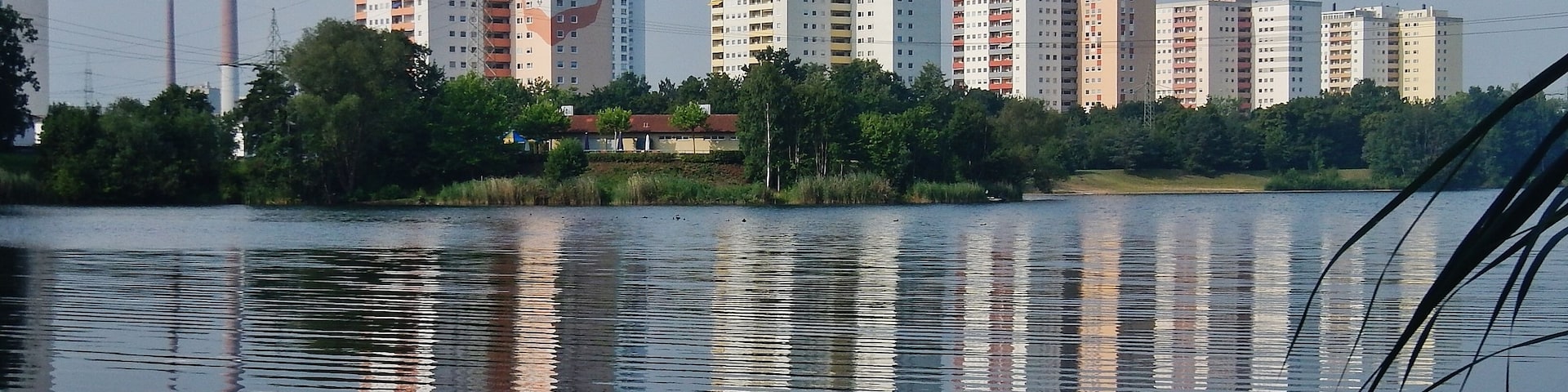 Mainparksee beim Campingplatz Mainparksee mit Hochhäusern am "Oscheffer Meer": Entstehung 1955 bis 1964. Der See ist entstanden aus der Kiesgrube Weiß.