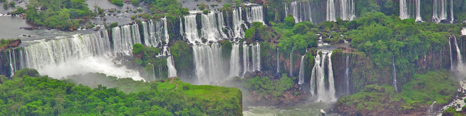 A series of waterfalls surrounded by dense green forest.