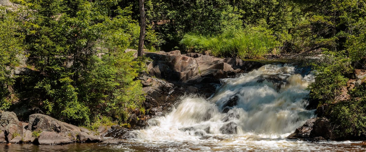 Twelve Foot Falls on the Pike River within Twelve Foot Falls County Park near Dunbar, Wisconsin flowing fast in early June