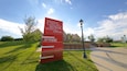 Ein rotes Schild des National Czech & Slovak Museum & Library mit angezeigten Öffnungszeiten.