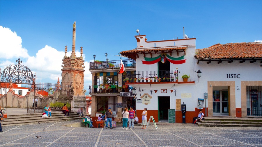 A plaza with a historic monument, a building with a red and white facade, and a HSBC bank.