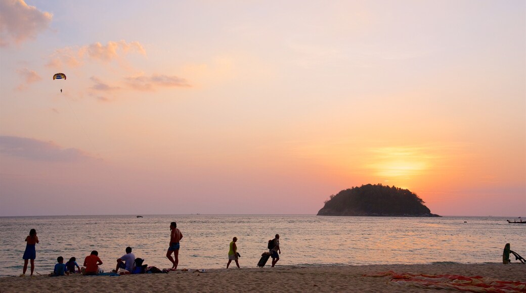 Kata-stranden som inkluderer solnedgang, bukt eller havn og strand