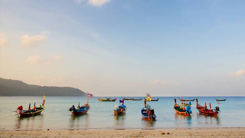 A beach with several colorful boats anchored in the water.