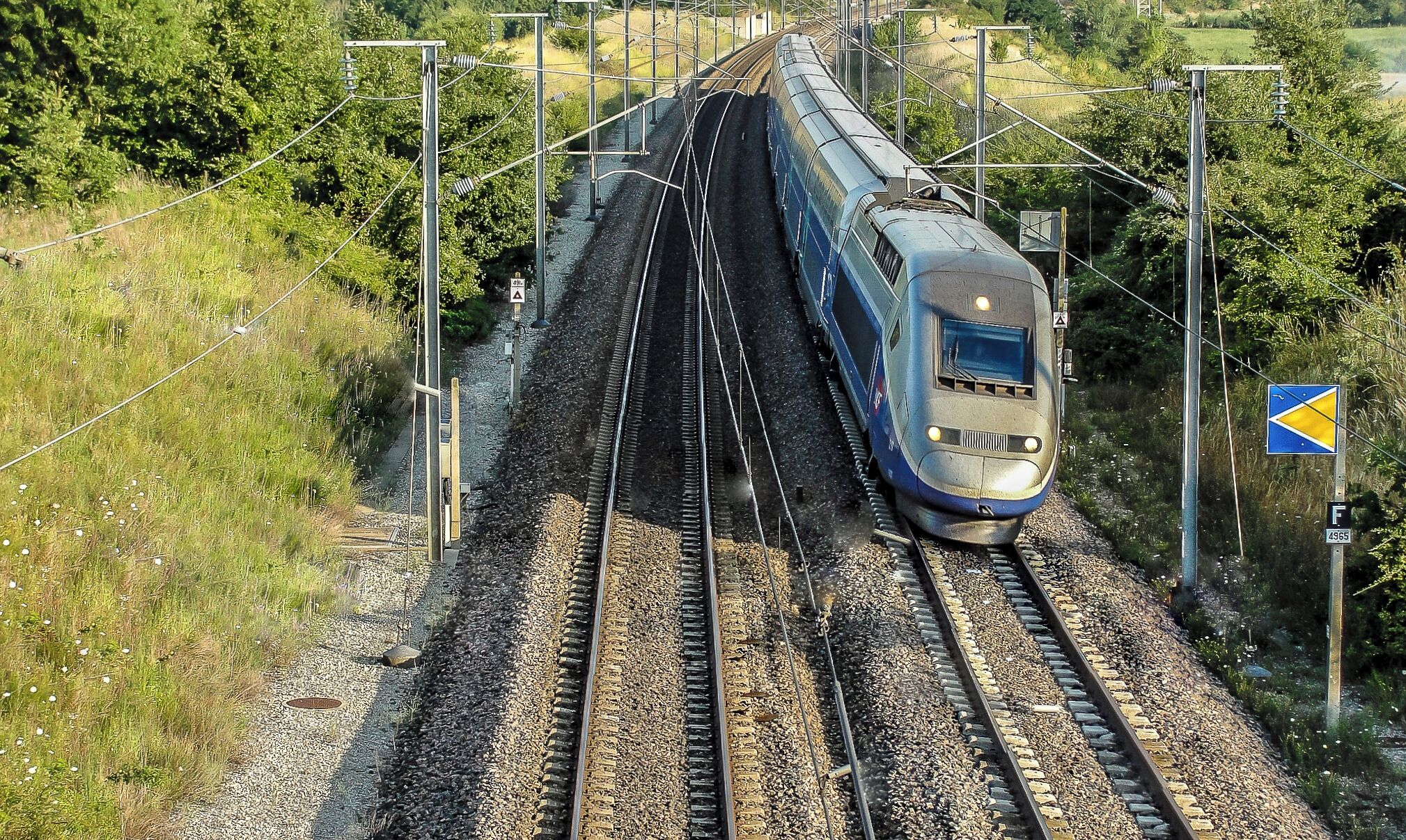 Met het geluid alsof er een aanzwellende tornado dichterbij komt, schieten de TGV treinen onderweg naar Paris Gare de Lyon, door het Zuid Franse landschap bij Piedmont.