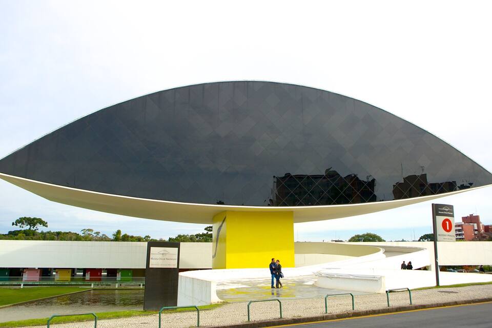 Una construcción grande y moderna con base amarilla y techo oscuro y reflectante.