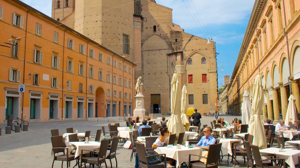 A street with outdoor cafes, a statue, and historic buildings.