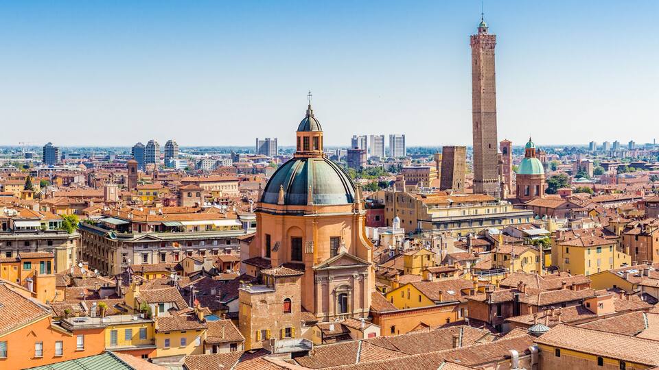 A cityscape with historic buildings, a prominent dome, and a tall tower.