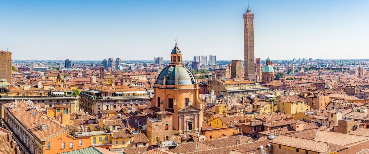 A cityscape with historic buildings, a prominent dome, and a tall tower.