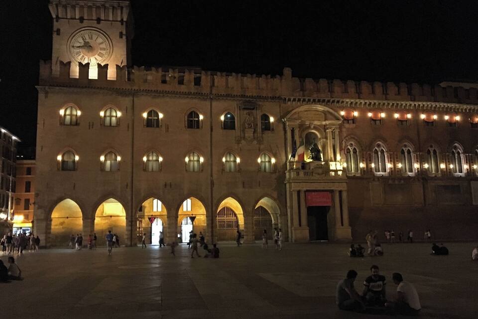 A historic building with a clock tower and arched windows at night.