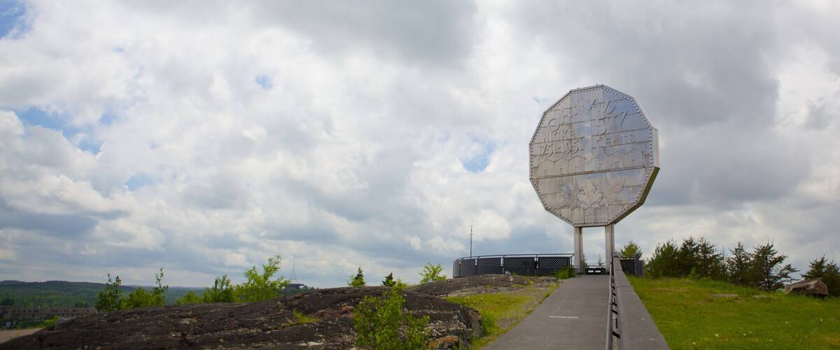 A large octagonal structure with inscriptions, set against a cloudy sky.