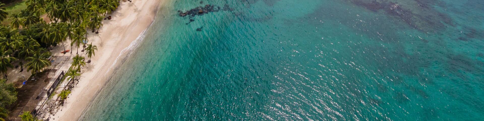 A tropical island with a sandy beach and turquoise waters.