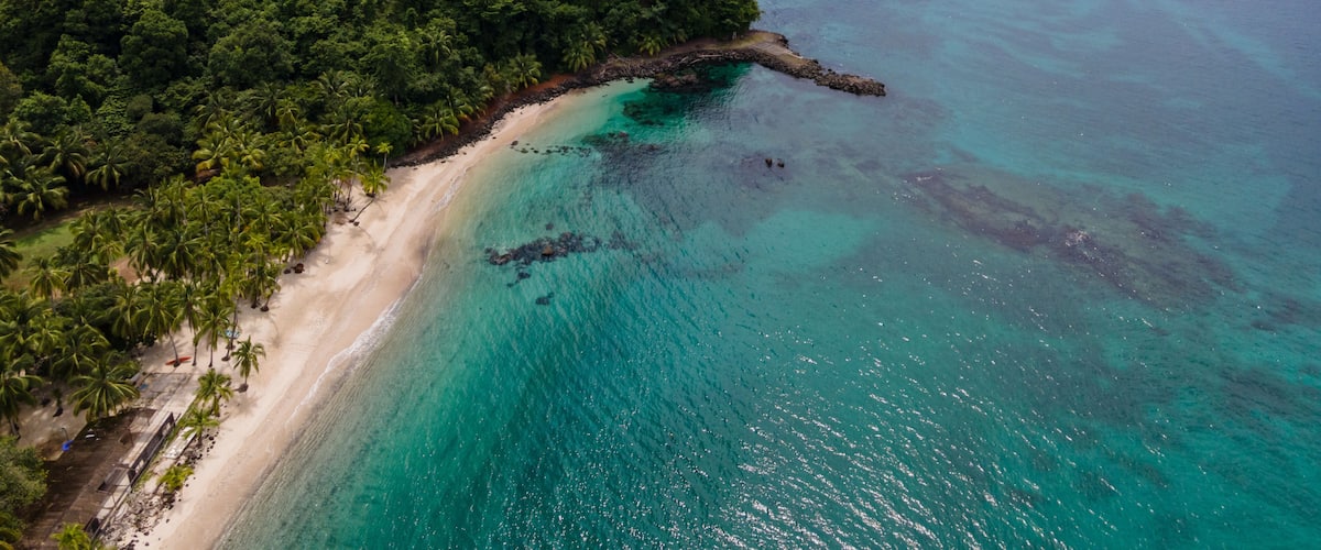 A tropical island with a sandy beach and turquoise waters.