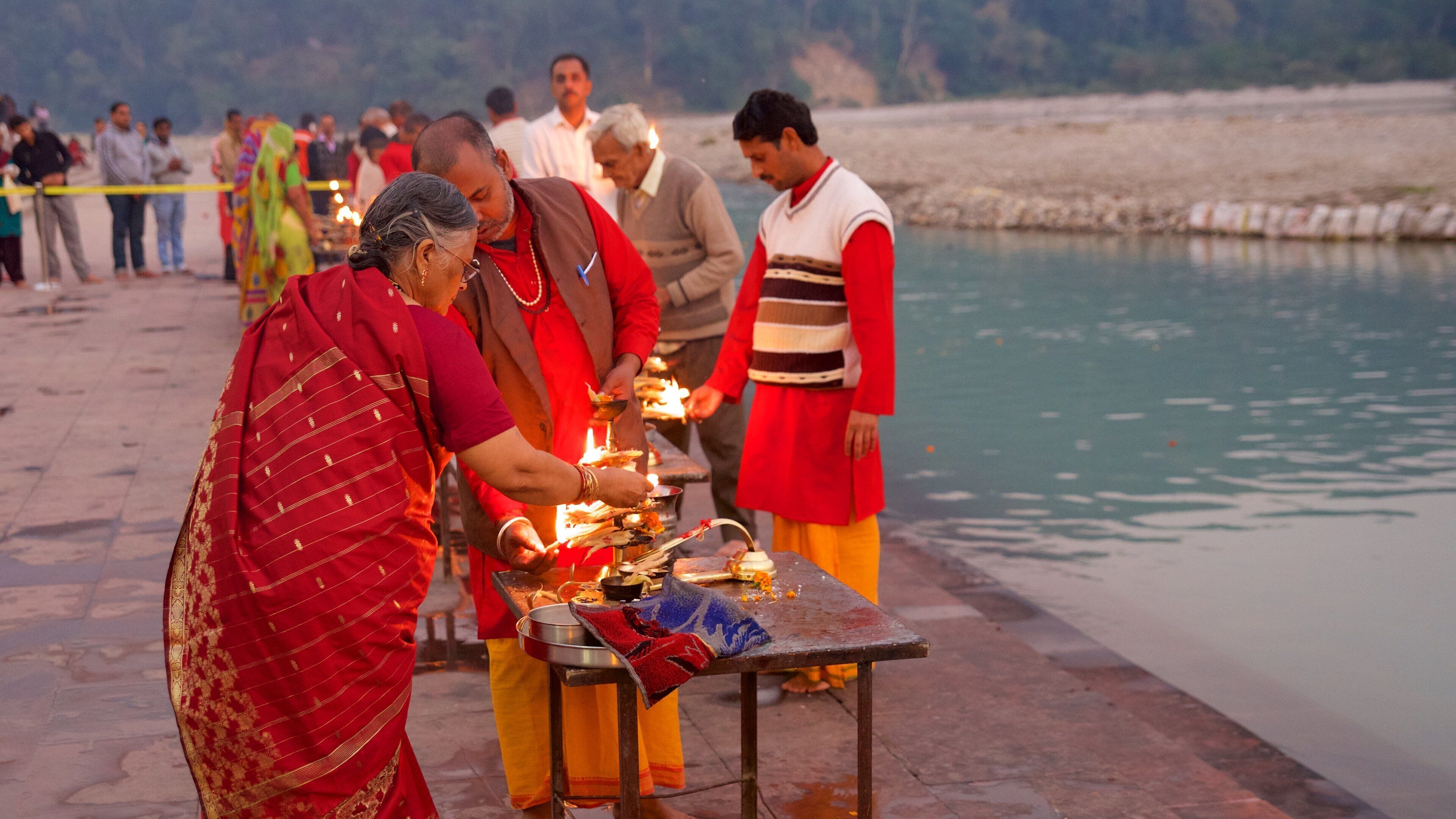A group of people performing a ritual by a riverbank.