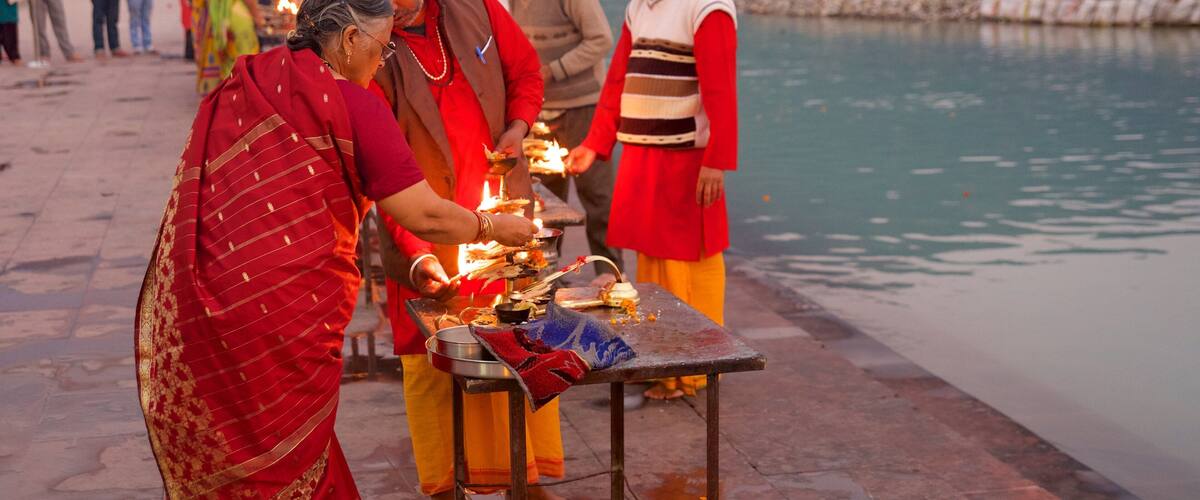 A group of people performing a ritual by a riverbank.