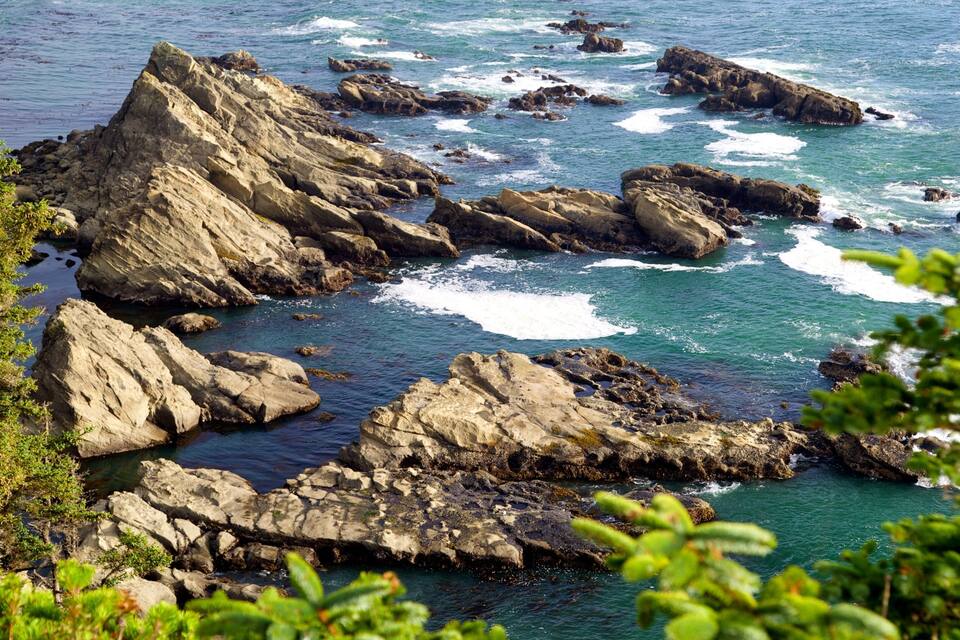 Una costa rocosa con olas rompiendo contra las rocas.