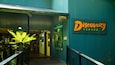 The entrance to the Discovery Centre with a sign, a staircase, and a large potted plant.