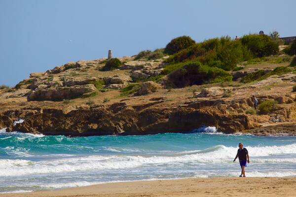 L\'Arrabassada Beach which includes general coastal views, a sandy beach and rugged coastline