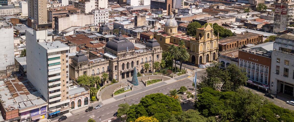 A cityscape with a prominent cathedral, a plaza, and dense urban buildings.