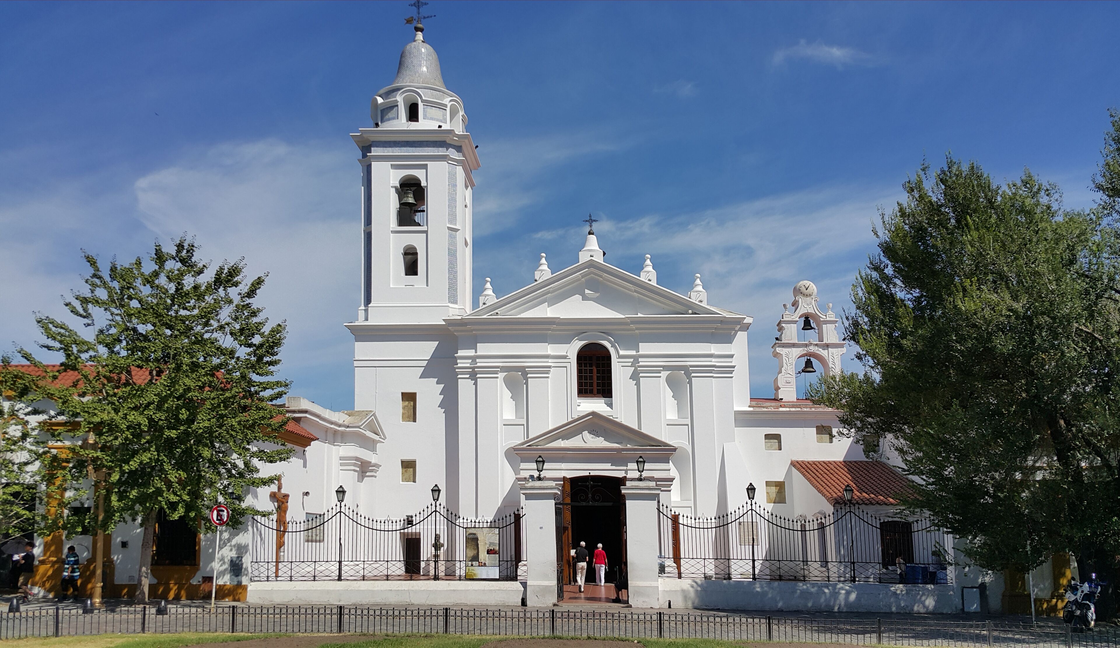 A white church with a bell tower and a clock.