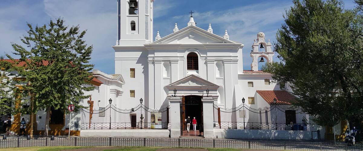 A white church with a bell tower and a clock.
