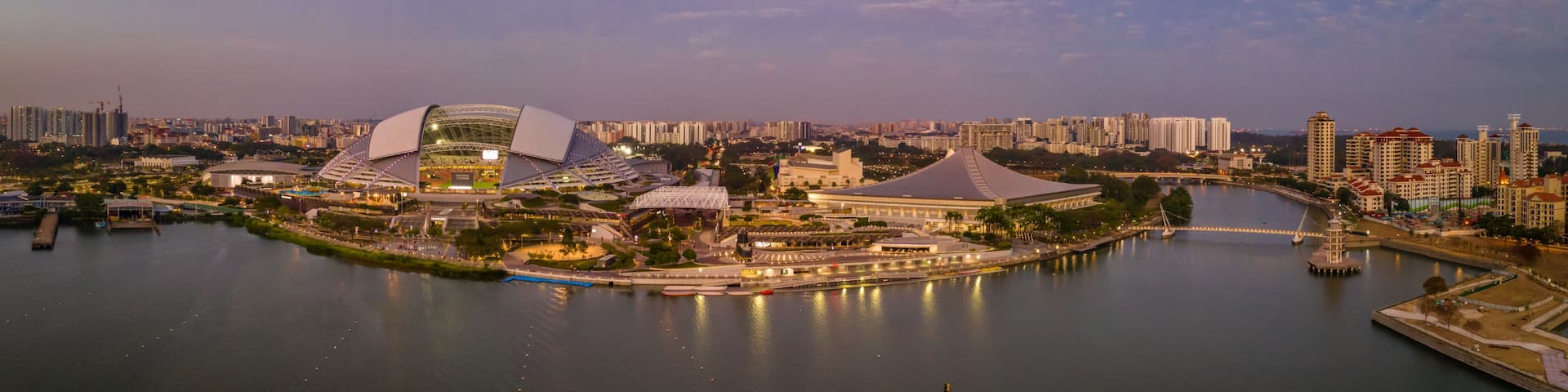 A cityscape with a river, modern architecture, and a bridge.