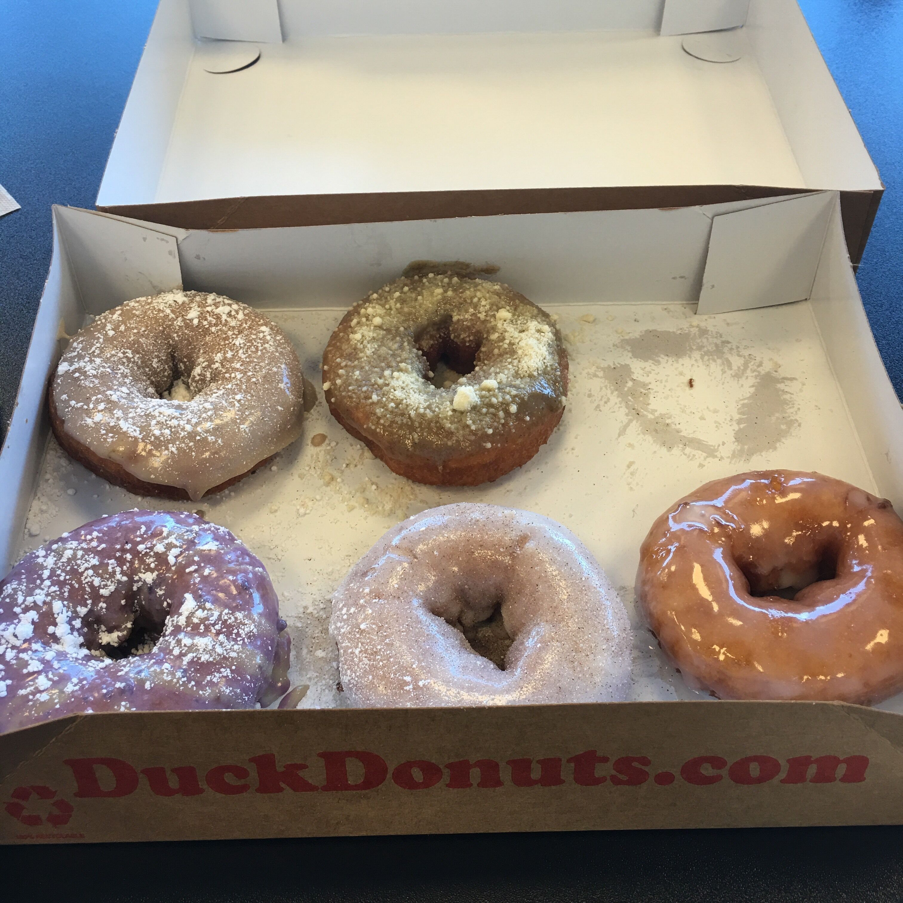 A box of DuckDonuts.com with five glazed donuts.