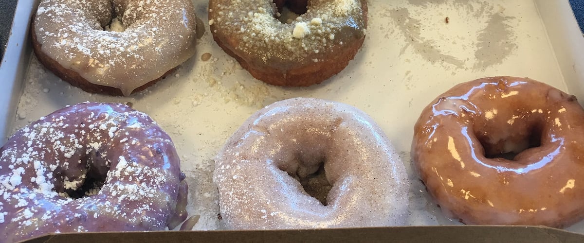 A box of DuckDonuts.com with five glazed donuts.