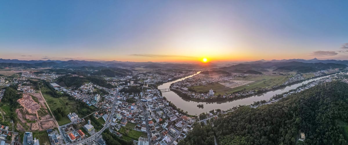A river winding through a town surrounded by mountains.