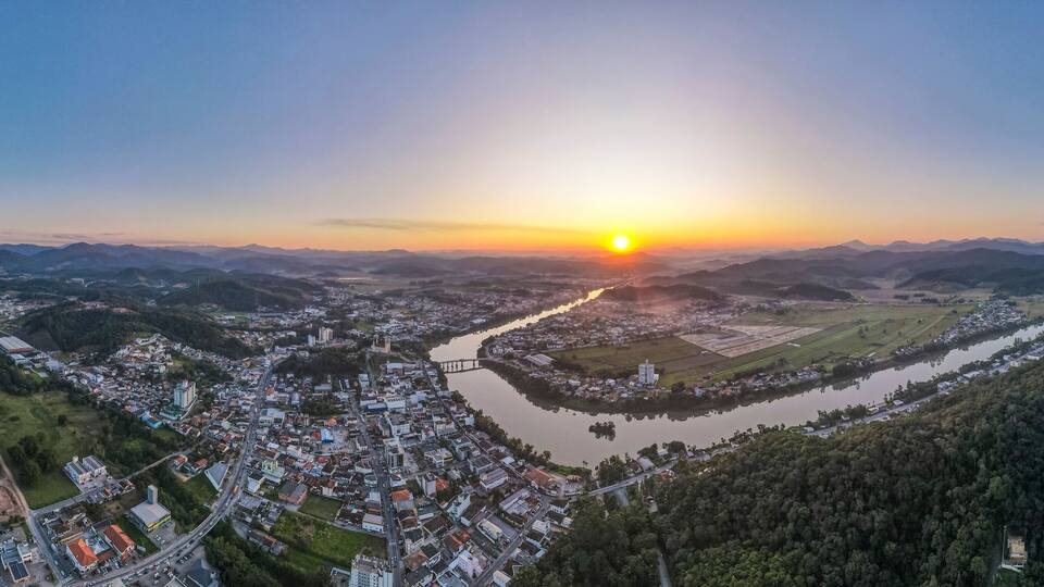 A river winding through a town surrounded by mountains.
