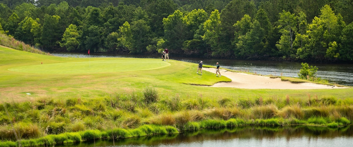 Grand Dunes Golf Course which includes golf and a pond as well as a small group of people