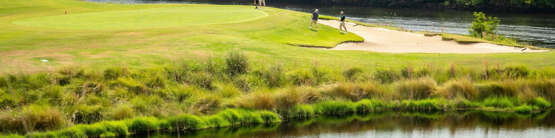 Grand Dunes Golf Course which includes golf and a pond as well as a small group of people