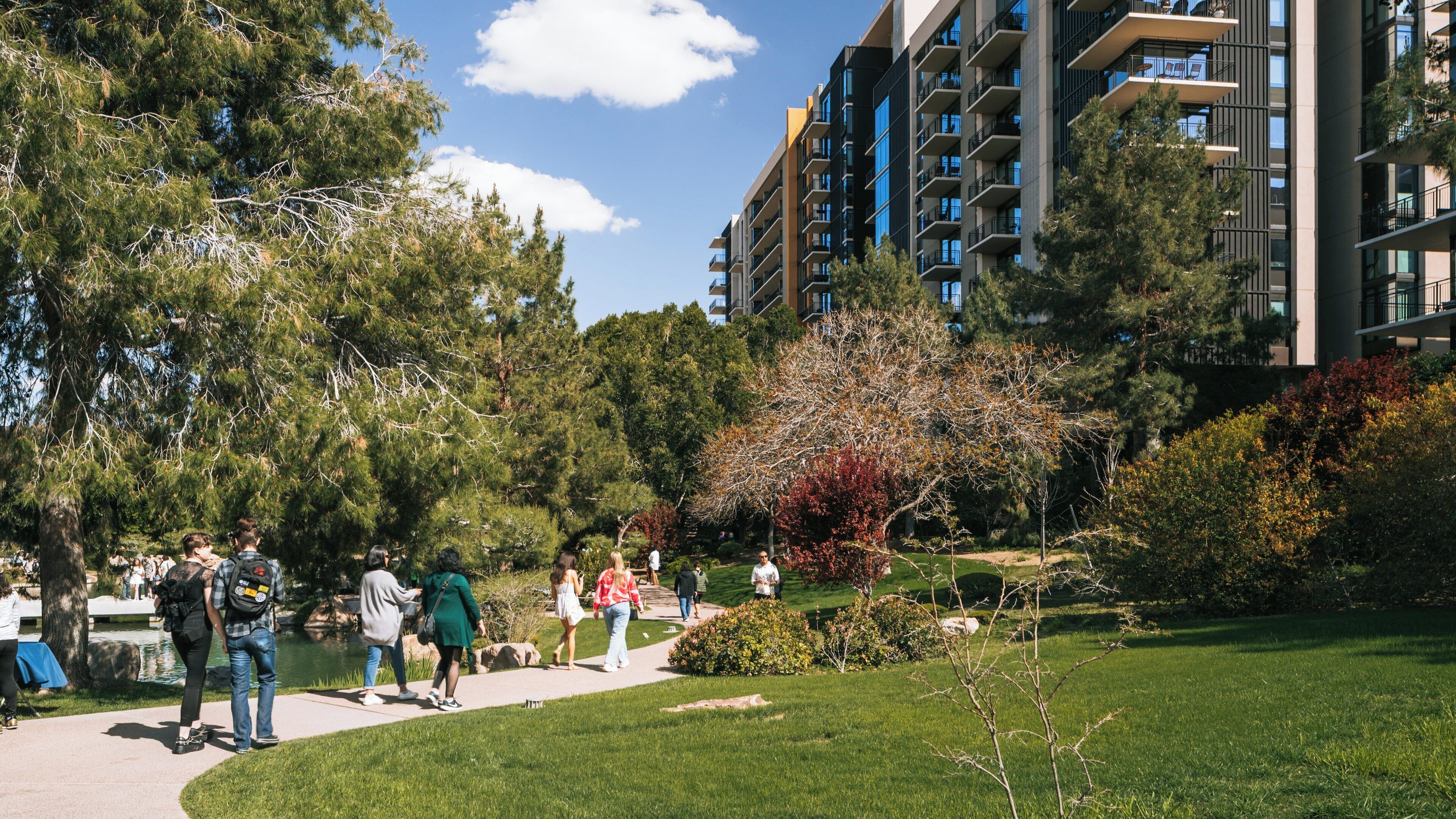 Visitors enjoy a sunny day exploring the tranquility of Japanese Friendship Garden in Phoenix, Arizona, surrounded by lush greenery and serene water features