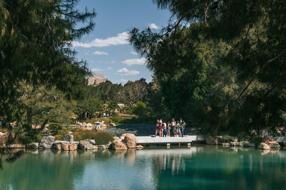 A serene lake surrounded by dense trees and a rocky shoreline.