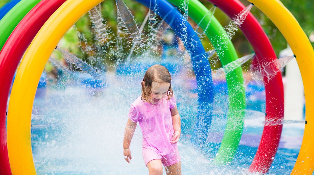 Little girl playing with fountain