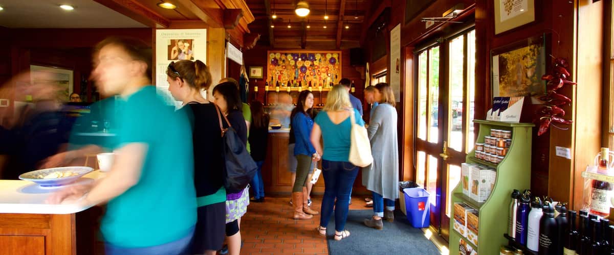 A busy restaurant interior with wooden beams, a bar area, and a display of wine bottles.