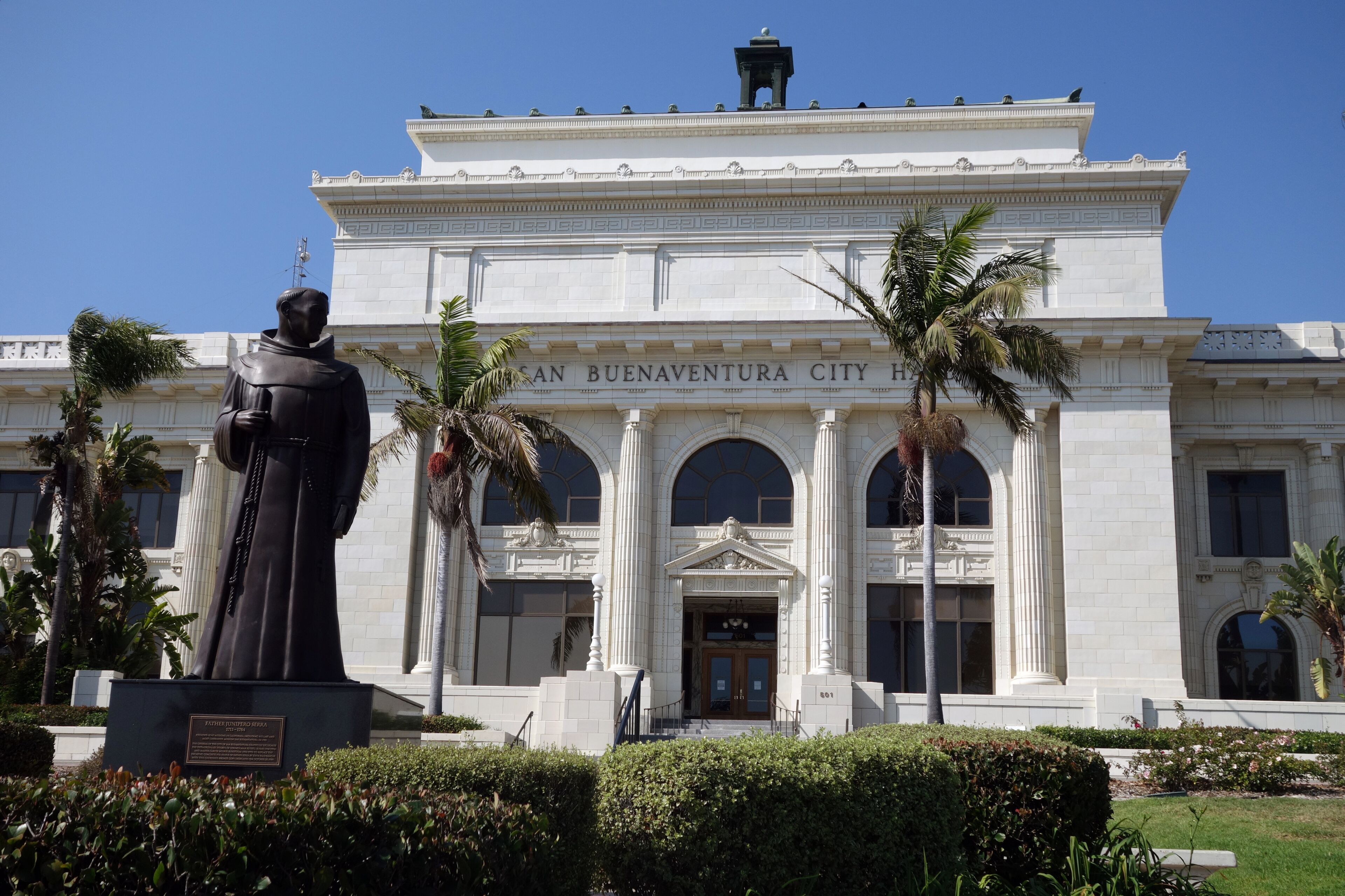 A statue in front of a building with 'SAN BUENAVENTURA CITY' on the facade.
