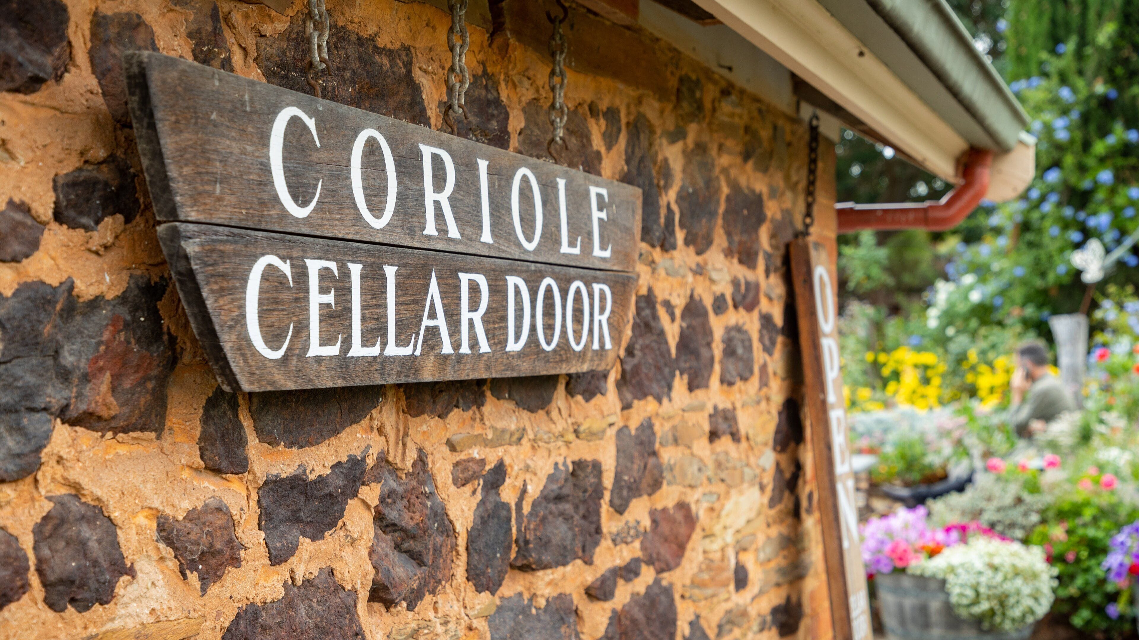 Une enseigne en bois, fixée à un mur de pierre, sur laquelle on peut lire : « CORIOLE CELLARDOOR ».