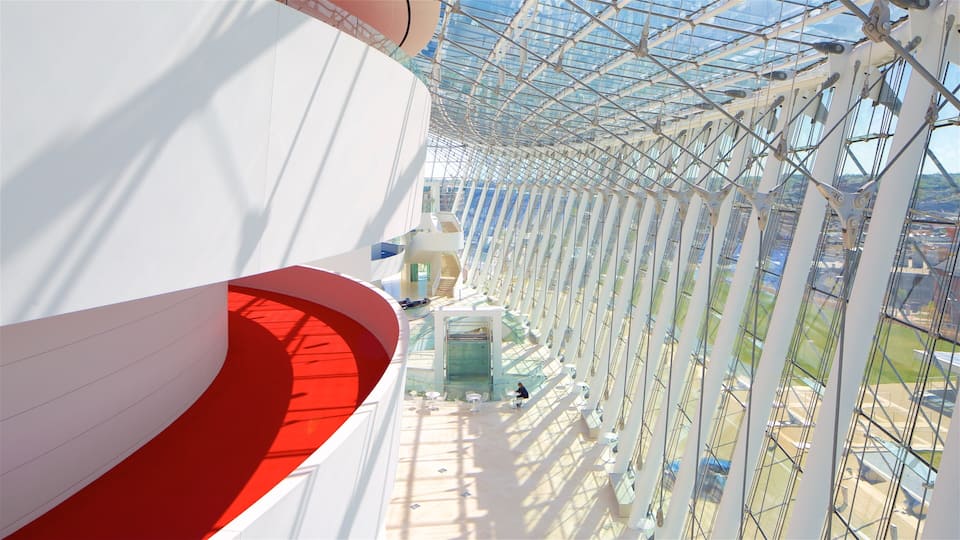 A modern architectural structure with a glass ceiling and red accents.