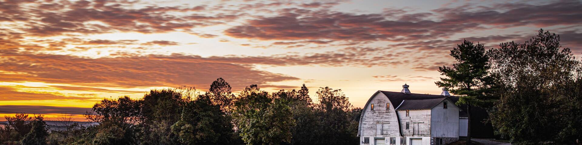 A white barn against the dawn sky in a rustic country scene