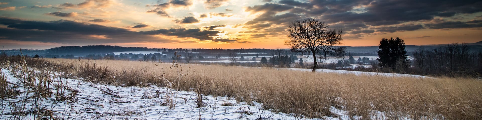 Beautiful sunrise of a hillside meadow overlooking fields and farmland in Pennsylvania during winter