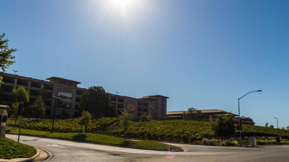 A sunny day at a roundabout with a large building in the background.