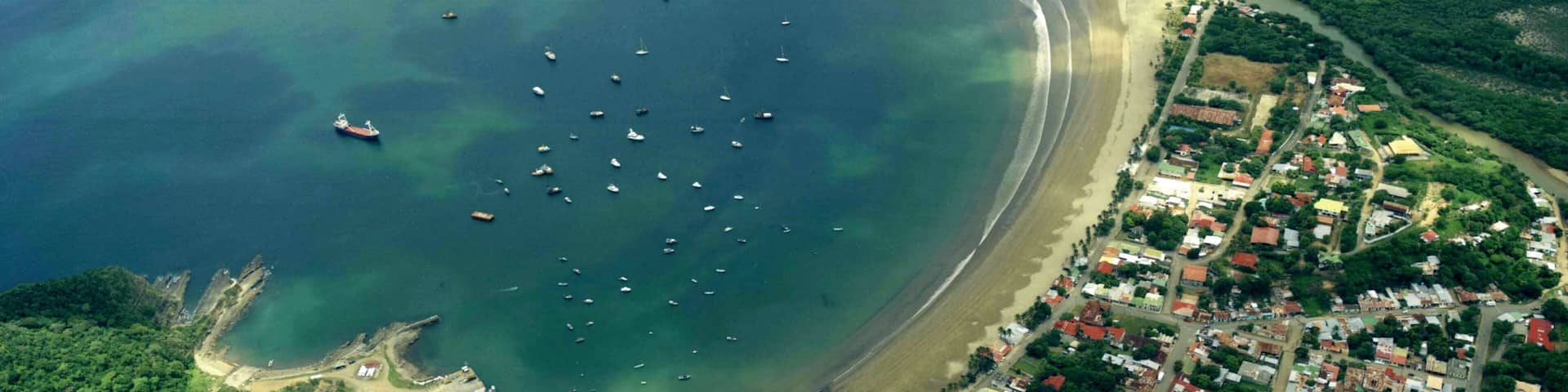 San Juan del Sur showing a sandy beach, a bay or harbor and a coastal town