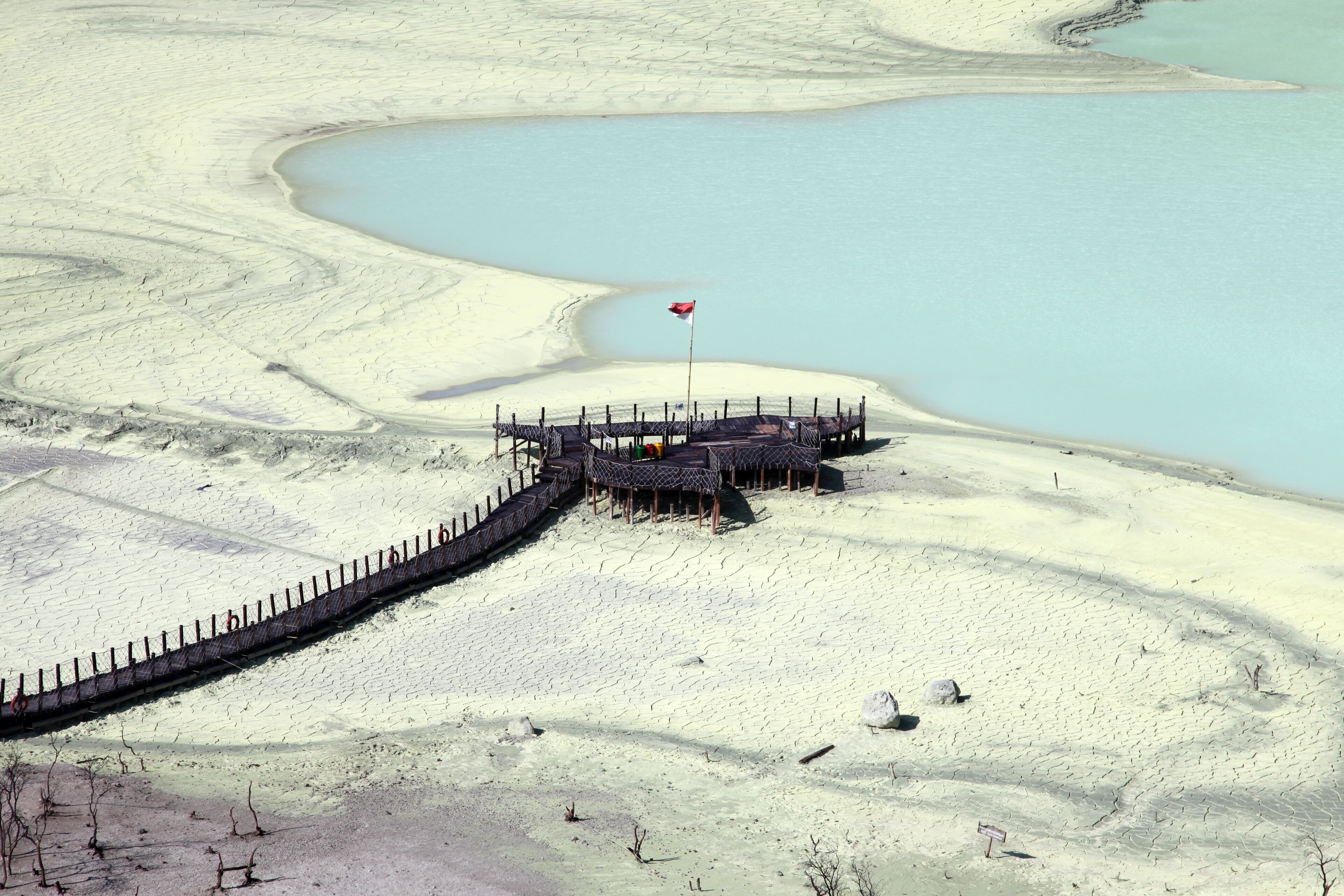 Una planicie salina con un muelle de madera y una bandera.