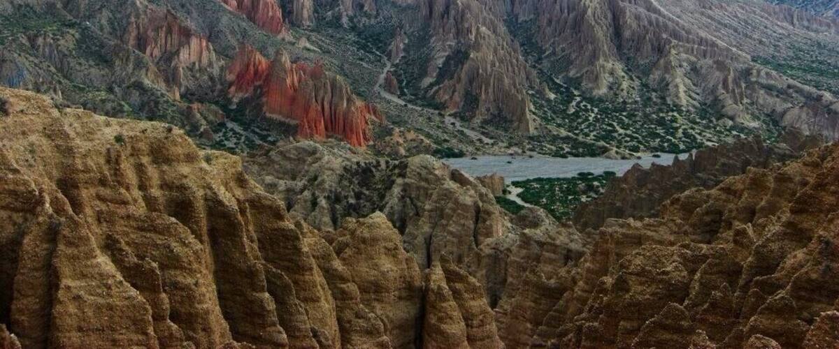 A rugged canyon landscape with steep cliffs and a river.