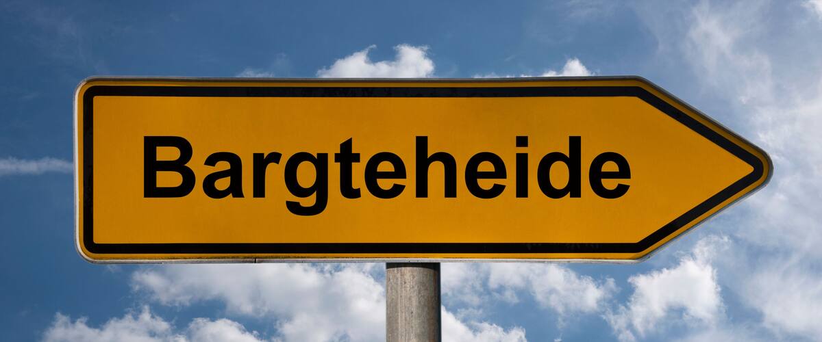 A directional sign with the text "Bargteheide" against a blue sky with clouds.
