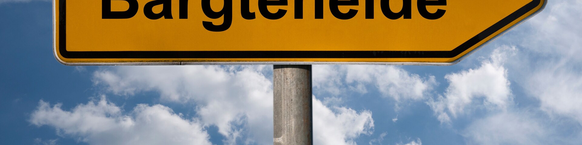 A directional sign with the text "Bargteheide" against a blue sky with clouds.