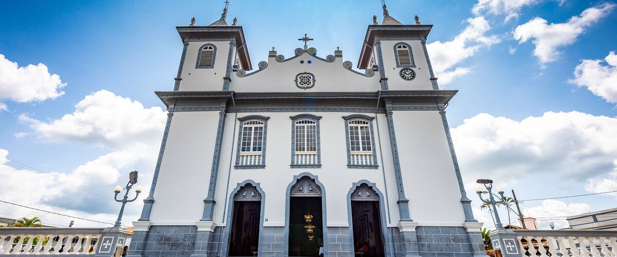 A white church with two towers and a cross on top.