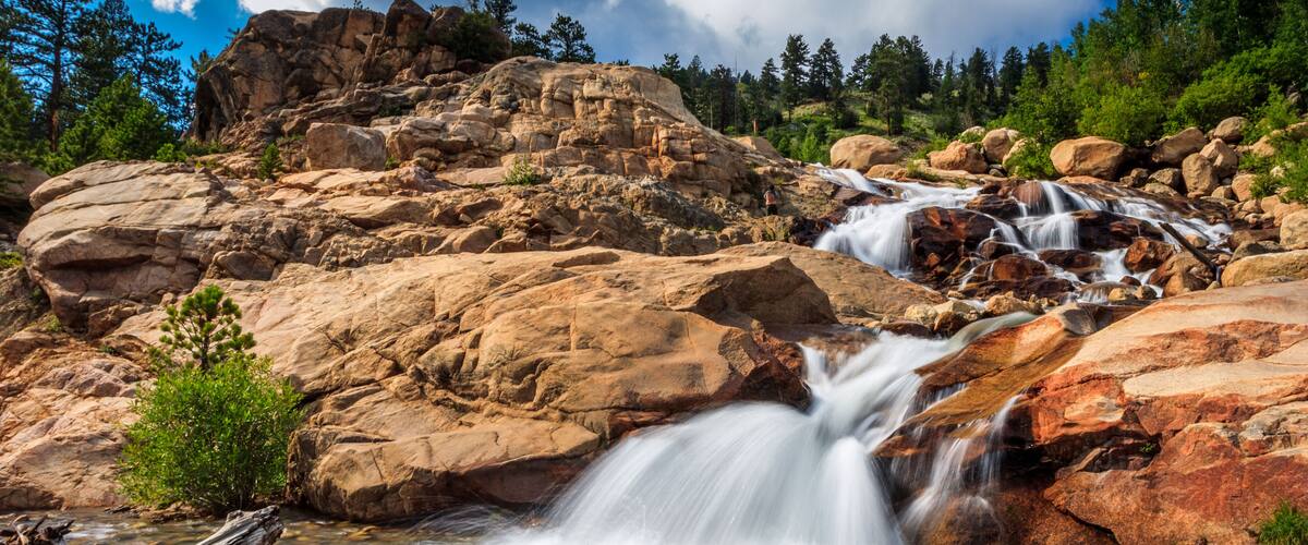 A waterfall cascading over rocks in a forested area.